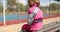 A child with a broken arm outdoors near a playground fence.