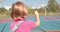 A child with a broken arm outdoors near a playground fence.