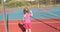 A child with a broken arm outdoors near a playground fence.