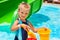 Child with bucket in swimming pool