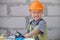 Child in building helmet, hard hat. Repair home. Child dressed as a workman builder. Portrait little builder in hardhats