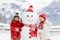 Child building snowman. Kids build snow man. Boy and girl playing outdoors on snowy winter day. Outdoor family fun on Christmas