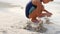 A child builds a sand castle on the seashore