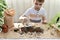 The child is busy planting micro greens pots. The boy starts watering a jet of water planted in the ground seeds