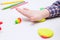 Child busy playing with plasticine on a white table