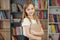 Child buys books in bookstore for learning or reading. Girl choosing book in school library