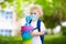 Child with candy cone in school in face mask