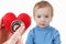 Child and cardiologist, heart symbol in hand, stethoscope.