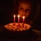 : the child carefully looks at the candles on the birthday cake