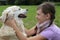 Child caressing dog on a meadow