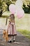Child Carrying Balloons and Dragging Her Teddy