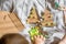 A child carves  Christmas tree from cardboard. Christmas decoration, hand made and Zero waste. child makes crafts on the bed at