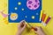 A child carves yellow stars for crafts on the theme of space.