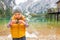 Child checking photos in camera on lake braies