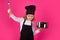 Child chef cook with cooking pot and ladle. Child wearing cooker uniform and chef hat preparing food on kitchen, studio