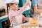 child in chef hat and apron whisking eggs