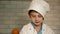 Child chef in a hat stained with flour cooks in the home kitchen. Caucasian preschooler boy helps to cook food. Home cooking. Cook
