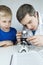 Child chemist. Teacher shows a visual experiment. A science mentor teaches an experimental approach. Microscope, petri dish,
