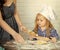 Child Childhood Children Happiness Concept. Child with serious face learning to roll dough