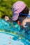 Child in the children`s pool catches toy fish. Shallow depth of field