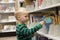 Child choosing a book from the Library shelf