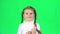 Child is clapping her hands and then shows thumbs up. Greenscreen. Slow motion