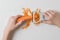 A child cleans carrots with a plastic knife.