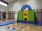 Child climbing into a base fort made of mats and pads