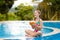 Child with coconut drink. Kids in swimming pool