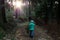 Child collecting branches of wood while on a walk with family