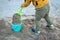 The child collects a large shovel sand in a bucket and builds a tower