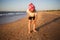 child collects seashells in summer on sunny evening on beach outdoor.