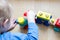 The child collects a toy wooden train.