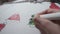 Child colouring Christmas tree with pencil and drawing toy balls