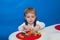 A child concentrates constructing a house from a designer