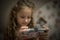 Child Concentration, Female Digital Native Looking Down Holding Technology. A concentrated female digital native looking down