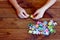 Child connects puzzles. A lot of puzzles on wooden table