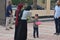 A child contributes sweets during Eid Al Adha religious rituals in the open air space near the mosque,