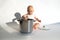 Child cook, food boy. Little cute baby chef sitting near big cooking pot with kitchen, utensils, accessories on white