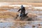 Child creating a large splash with his quad