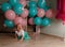 The child cries, gets angry, a little girl, a child, sits on the floor and cries, wrinkled her nose, near the balloons, a holiday.