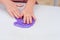 Child crumples slime. Close up of hands. Process of making slime.Purple magic glitter slime on a white background.