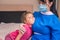 Child cuddles with a doctor Doctor in a medical mask hugs a little girl. A nurse talking to a child about vaccination. The baby is