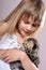 Child cuddling a kitten