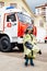 Child, cute boy, dressed in fire fighers cloths in a fire station with fire truck, childs dreamed profession