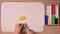 The child cuts off piece of a stack of yellow plasticine for crafts, close-up, top view