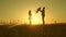 Child, dad and mom play in the meadow in the sun. concept of a happy childhood. mother, father and little daughter