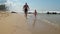 Child with daddy run in coastline against sky slow motion