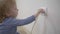 Child in a dangerous situation at home, little boy tries to insert a power plug into electric socket close-up