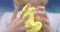 Child delightfully playing with homemade yellow slime, stretches slime to the sides, an engaging sensory activity